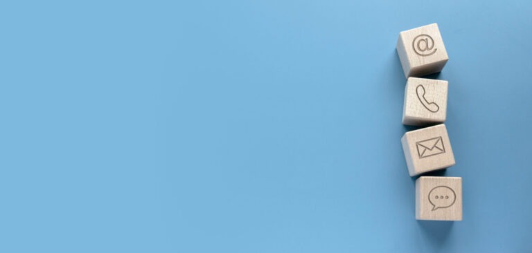 Erinevad kontaktiikoonid puidust kuubikul. Äriregistri kontaktandmed korras.